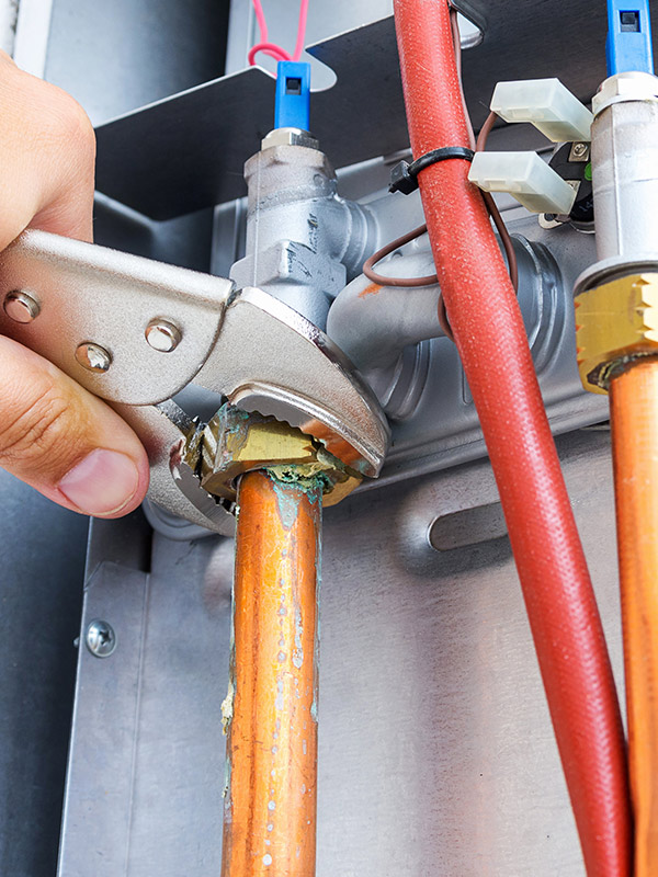 hvac-technician-with-tool-close-up-repairing-furnace-many-la