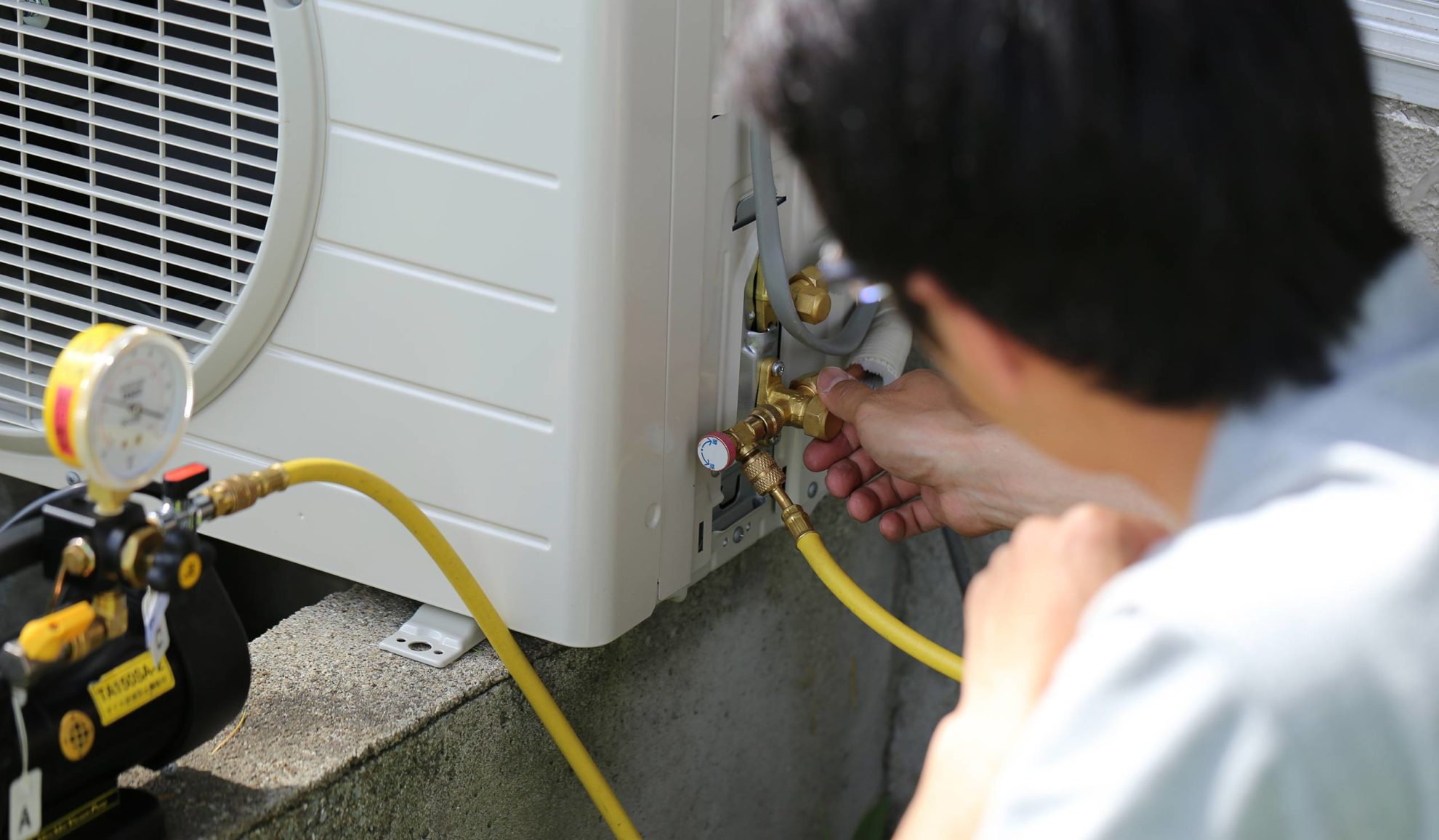 technician-close-up-installing-air-conditioner-unit-at-property-exteriors-many-la