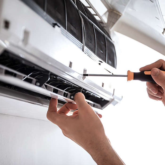technician-with-screwdriver-close-up-installing-air-conditioner-at-property-many-la