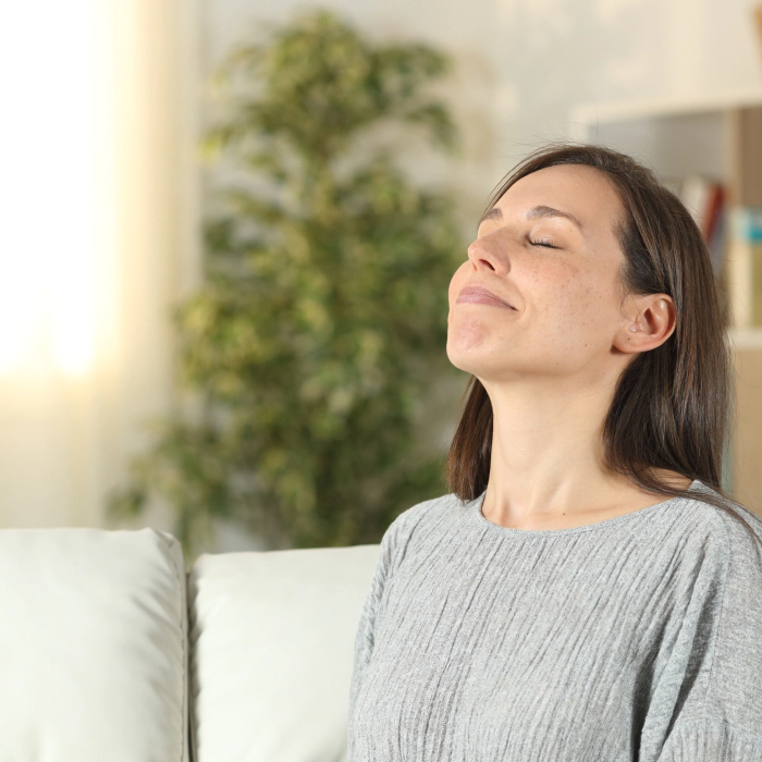 relaxed woman at home breathing fresh air