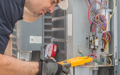 hvac-technician-with-protection-equipment-doing-maintenance-at-units-many-la